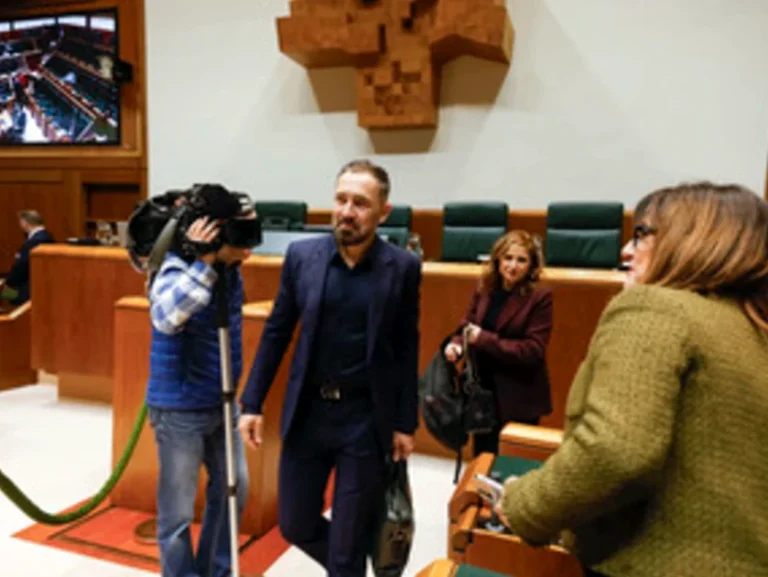 Personas en un salón de actos con cámaras y asientos verdes