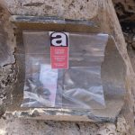 Bolsa transparente con etiqueta sobre amianto en una roca