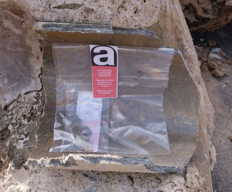 Bolsa transparente con etiqueta sobre amianto en una roca