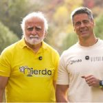 Dos hombres sonrientes en un campo de agricultura orgánica.