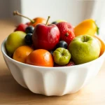 Tazón blanco con variedad de frutas frescas y coloridas.