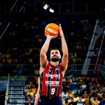 Jugador de baloncesto lanzando a canasta en un partido