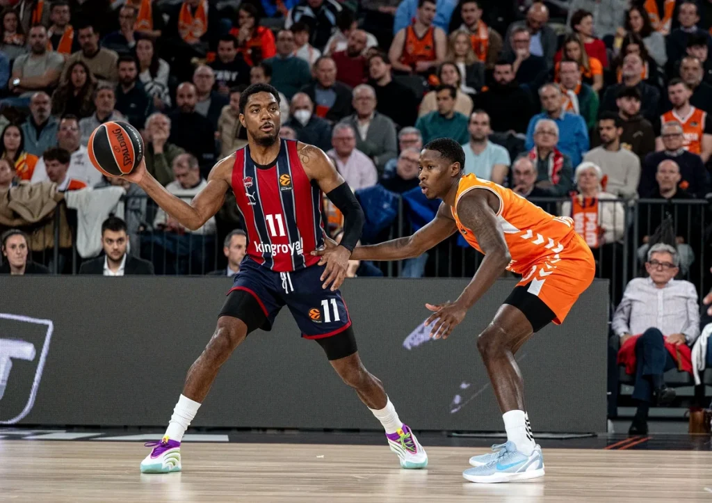 Jugador de Baskonia driblando el balón en un partido de baloncesto
