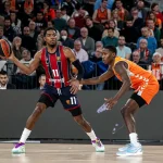 Jugador de Baskonia driblando el balón en un partido de baloncesto