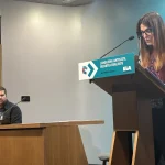 Mujer leyendo un informe en una conferencia de prensa