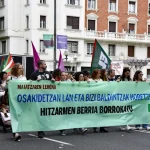 Manifestantes sosteniendo pancarta de ELA en protesta laboral