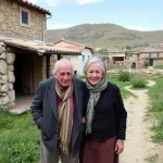 Pareja de ancianos sonrientes en un entorno rural.