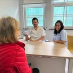 Dos profesionales de la salud atienden a una paciente en consulta