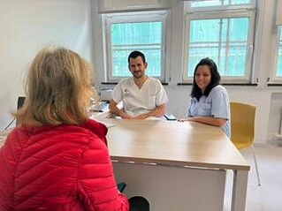 Dos profesionales de la salud atienden a una paciente en consulta