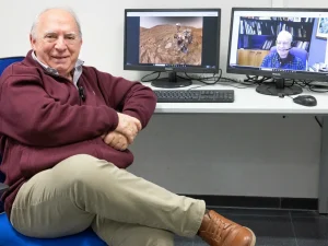 Investigador sentado frente a dos monitores mostrando Marte