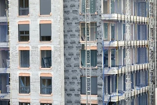 Edificio en construcción con andamios y ventanas sin terminar