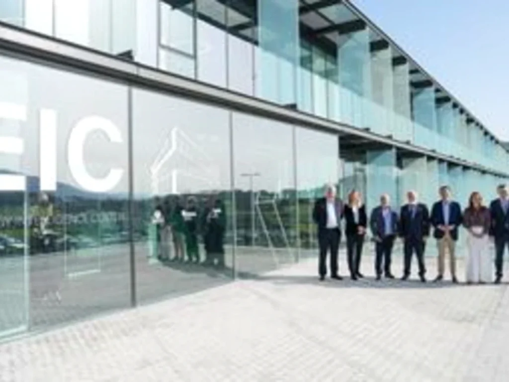 Grupo de personas frente a un edificio moderno de cristal