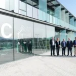 Grupo de personas frente a un edificio moderno de cristal