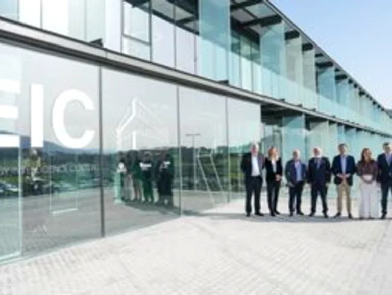 Grupo de personas frente a un edificio moderno de cristal