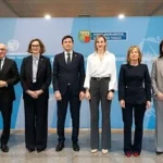 Grupo de personas posando en un evento oficial en un edificio gubernamental.