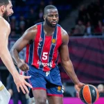 Eugene Omoruyi driblando con balón en un partido de baloncesto.