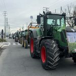 Tractores en fila en una carretera con pancartas