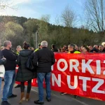 Grupo de personas protestando con pancarta roja en Aiaraldea.