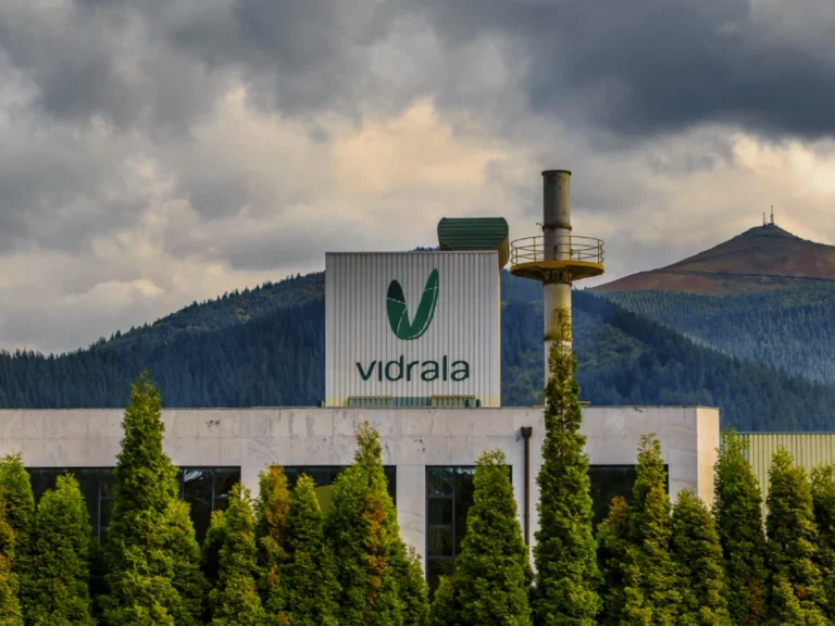 Fábrica de Vidrala con montañas al fondo y nubes oscuras