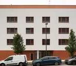 Edificio de apartamentos moderno en Euskadi con coches estacionados.