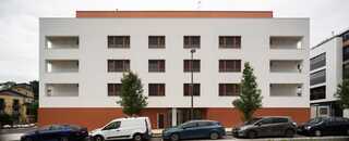 Edificio de apartamentos moderno en Euskadi con coches estacionados.