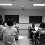 Grupo de personas sentadas en un aula mirando hacia el frente.