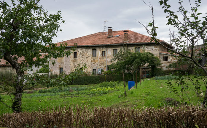 Casa de piedra con jardín en un entorno rural