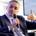 Hombre hablando con micrófono en un evento sobre hidrógeno