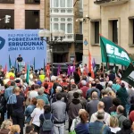 Manifestación con banderas y pancarta en apoyo a la negociación salarial en Euskadi.