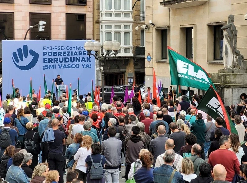 Manifestación con banderas y pancarta en apoyo a la negociación salarial en Euskadi.