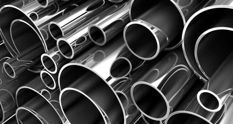 Tuberías de acero inoxidable apiladas en diferentes tamaños.