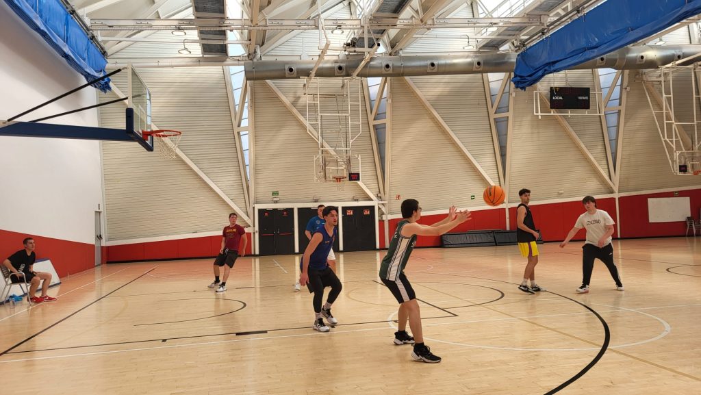 Niños jugando baloncesto en un gimnasio deportivo