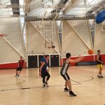 Niños jugando baloncesto en un gimnasio deportivo