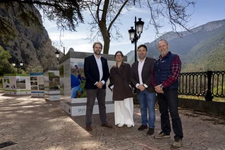 Cuatro personas posan frente a una exposición al aire libre en Sobrón.