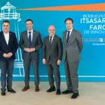 Cuatro hombres posando frente a un fondo azul con texto sobre innovación