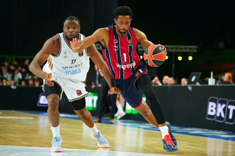 Jugador de Kosner Baskonia driblando el balón en un partido de baloncesto.