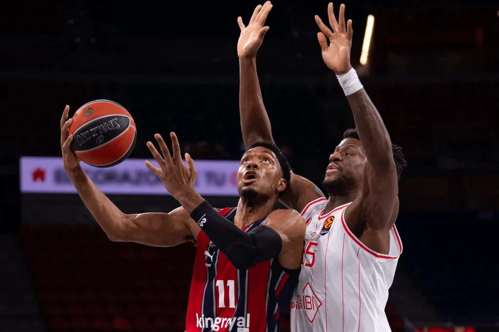 Jugador de Kosner Baskonia lanzando a canasta en un partido de baloncesto.