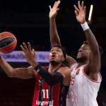 Jugador de Kosner Baskonia lanzando a canasta en un partido de baloncesto.