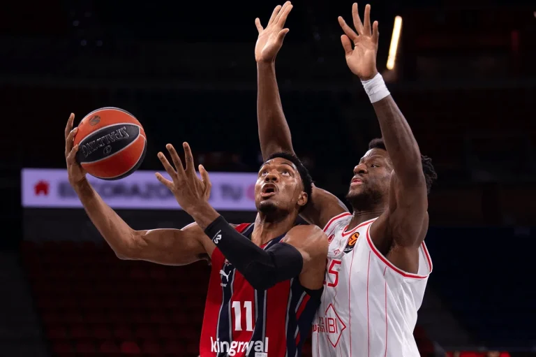Jugador de Kosner Baskonia lanzando a canasta en un partido de baloncesto.