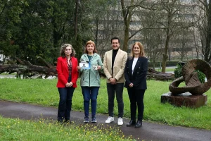 Cuatro personas posando en un parque con esculturas y vegetación