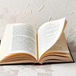 Libro abierto sobre una superficie clara y texturizada.