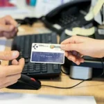 Persona entregando una tarjeta sanitaria en un mostrador