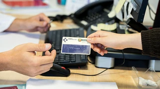 Persona entregando una tarjeta sanitaria en un mostrador