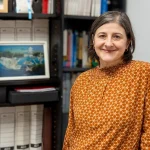 Mujer sonriente en un entorno de oficina con estanterías