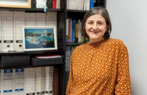 Mujer sonriente en un entorno de oficina con estanterías