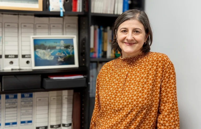 Mujer sonriente en un entorno de oficina con estanterías