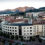 Vista panorámica de Laudio con montañas al fondo y edificios urbanos.