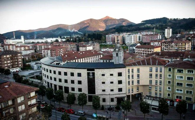 Vista panorámica de Laudio con montañas al fondo y edificios urbanos.
