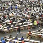 Gran sala con mesas y personas en un examen masivo