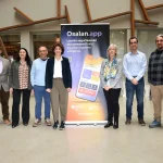 Grupo de personas posando frente a un banner de Osalan.app